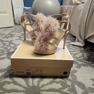 Michael Kors pink suede sandals with feather details.